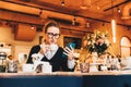 Young business woman in glasses sits in cafe at table, uses smartphone, drinking coffee. Girl working, chatting Royalty Free Stock Photo