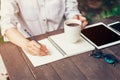 Young business woman hand with pencil writing on notebook. Woman