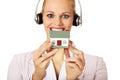 Young business woman in headset holding house model Royalty Free Stock Photo