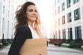 Young business woman hold in hand document folder and securities among urban space and talking on the phone Royalty Free Stock Photo