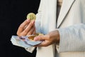 Young business woman holding British pounds and bitcoin in hands, close up of female hands with cash equivalents