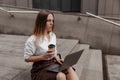 Young business woman holding coffee and laptop of the modern office building background Royalty Free Stock Photo