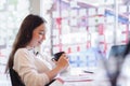 Young business woman holding a cup of coffee in co-working or coffee shop. Business people working in co-working concept. Royalty Free Stock Photo