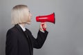 Young business woman holding megaphone loudspeaker shouting announcement leadership. Beauty blonde lady Royalty Free Stock Photo