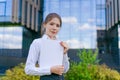 Young business woman holding papers in business clothes on city street against Royalty Free Stock Photo