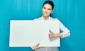 Young business woman holding sign board shows thumb