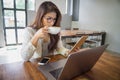 Young business woman holding tablet computer and drinking coffee in coffee shop. Royalty Free Stock Photo