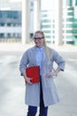 The young business woman holds in hand folder with documents. Businesswoman standing next to the business center Royalty Free Stock Photo
