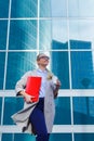 The young business woman holds in her hands folder with documents and cup of coffee. Businesswoman standing next to the business Royalty Free Stock Photo