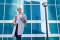 The young business woman holds in her hands folder with documents and cup of coffee. Businesswoman standing next to the business Royalty Free Stock Photo