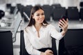 Young business woman at international airport, making selfie with mobile phone and waiting for her flight. Female Royalty Free Stock Photo