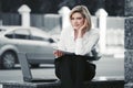 Young business woman with laptop sitting at office building Royalty Free Stock Photo