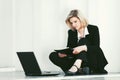 Young business woman with laptop sitting at the wall Royalty Free Stock Photo