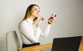 Young business woman looking in the mirror and using lipstick at her worlplace Royalty Free Stock Photo