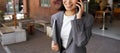 Young business woman manager wearing suit talking on phone making call outdoor. Royalty Free Stock Photo