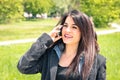 Young business woman in the park with smartphone