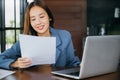 young business woman reading report document compare with laptop computer Royalty Free Stock Photo