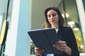 Young business woman reads financial news using tablet and Internet technology, elegant Manager in a business suit communicates