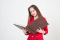 young business woman in a red suit holding a large book with documents on a light background Royalty Free Stock Photo