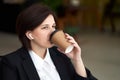 Young business woman relaxing, listening music and drinking coffee during break from work Royalty Free Stock Photo