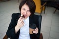 Young business woman relaxing, listening music and drinking coffee during break from work Royalty Free Stock Photo