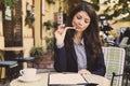 Young business woman riding and sign in documents at cafe. Royalty Free Stock Photo