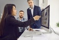 Young business woman showing her colleagues stats financial data on pc computer screen with diagram Royalty Free Stock Photo