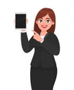 Young business woman showing or holding a blank screen digital tablet computer and pointing index finger. Female character design. Royalty Free Stock Photo