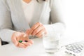 Young business woman sick in the office, hand holding pills and Royalty Free Stock Photo