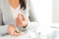 Young business woman sick in the office, hand holding pills Royalty Free Stock Photo