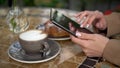 Young business woman sits in a cafe and writes text messages on a tablet close-up. Royalty Free Stock Photo