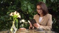 Young business woman sits in a cafe and writes text messages on a tablet. Royalty Free Stock Photo