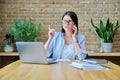 Young business woman sitting at desk with computer in office, talking on phone Royalty Free Stock Photo