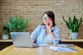 Young business woman sitting at desk with computer in office, talking on phone Royalty Free Stock Photo