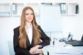 Young business woman sitting at desk in office Royalty Free Stock Photo