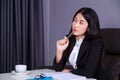 Business woman sitting at the desk and thinking to her work Royalty Free Stock Photo