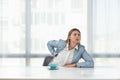 Young business woman sitting in the office in formal wear at empty desk with cup of coffee have a back pain from long stressful Royalty Free Stock Photo