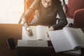 Young business woman sitting at table and taking notes in notebook, On table is laptop, Smartphone and cup of coffee, Student Royalty Free Stock Photo