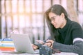 Young business woman sitting at table and using smartphone. On desk is tablet computer. Royalty Free Stock Photo