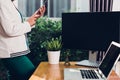 Young business woman stand using smart phone calling to customer on her working with laptop computer Royalty Free Stock Photo