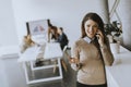 Young business woman standing in the office and using mobile phone in front of her team Royalty Free Stock Photo