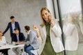 Young business woman standing in the office and using mobile phone in front of her team Royalty Free Stock Photo