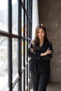 Young business woman standing to drinking coffee and thinking about the strategy of new startup while looking out the Royalty Free Stock Photo