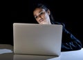 Young business woman or student girl working on laptop computer late at night bored and tired Royalty Free Stock Photo