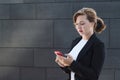 Young business woman in a business suit looks upset and displeased at the phone. girl receives and reads bad news. lady looks Royalty Free Stock Photo