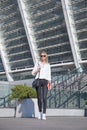 Young business woman in sunglasses with bag in the city standing with notebook