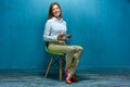 Young business woman with tablet sitting on chair. Royalty Free Stock Photo