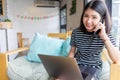 Young business woman talking on mobile phone and using laptop computer working in coffee shop. Royalty Free Stock Photo