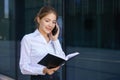 Young business woman talking on the phone and writes in notebook Royalty Free Stock Photo