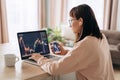 Female trader investor using stockmarket app on laptop and smartphone from home